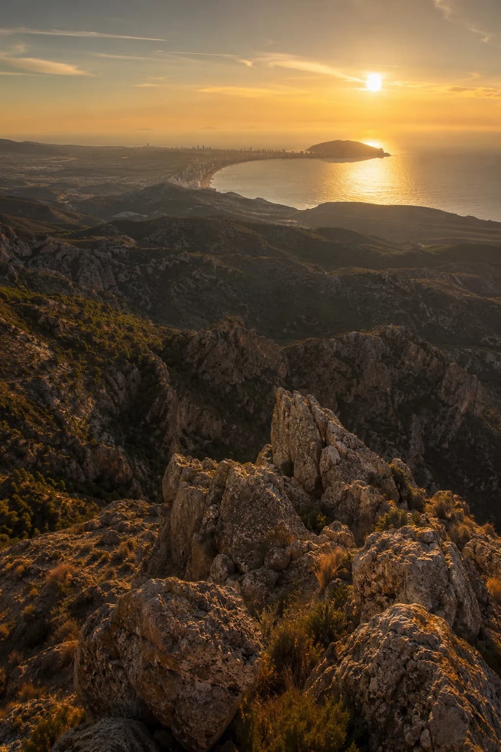 Golden-hour aerial view of Sierra Cortina above Benidorm, Mediterranean coastline